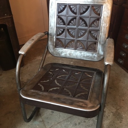 Rocking-Chair Américain 1950 aux motifs artistiques de dossier et d'assise, positionné dans un décor intérieur entouré de 93 armoires en bois de brocante. Brocante 93