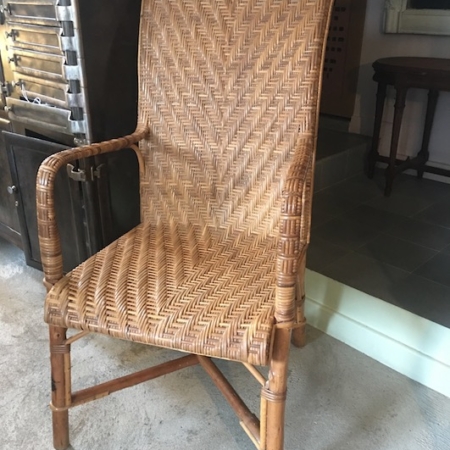 Le Fauteuil en Rotin 1960, doté d'un dossier haut et d'accoudoirs, est placé en intérieur sur un sol carrelé. Brocante 93