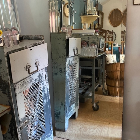 Chambre rétro vintage avec casiers rouillés, un grand Miroir Moustache 1950 en arc et une décoration éclectique visible dans le reflet. Brocante 93