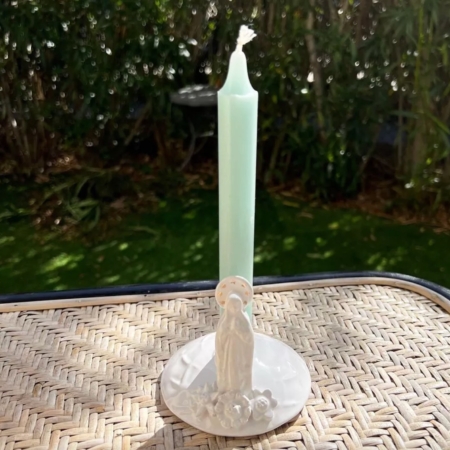 La Porte Bougie Madone, avec sa bougie verte et son support en céramique représentant une délicate statue de la Vierge Marie, ajoute un charme vintage à la surface en osier extérieure. Brocante 93