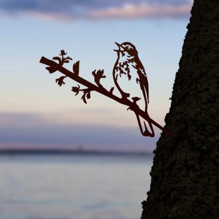 Nom du produit : Le Pipit des Arbres présente une silhouette artistique d'un oiseau perché sur une branche, sur fond de ciel de coucher de soleil vintage au-dessus de l'eau. Brocante 93