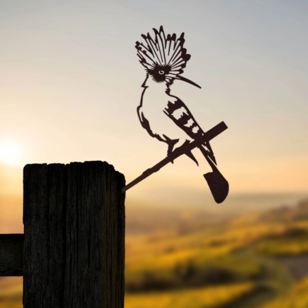 Silhouette de La Huppe Fasciée perchée sur un poteau en bois sur fond de paysage de coucher de soleil pittoresque, évoquant le charme d'une carte postale vintage. Brocante 93