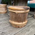 Un panier en bois patiné avec un couvercle, étiqueté « Fût à Saké Japonais 1960 », repose sur une terrasse en bois, évoquant le charme de la culture japonaise des années 1960. Brocante 93