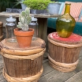 Le Fût à Saké Japonais 1960 fait office de table d'appoint, ornée de bocaux en verre, d'un cactus dans un pot en terre cuite et d'une bouteille en verre verte posée dessus. Brocante 93