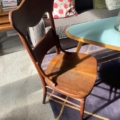 Une charmante Chaise de Bureau Américaine 1930 orne le salon ensoleillé, aux côtés d'un canapé cosy orné de coussins à pois et d'une table basse bleue. Brocante 93