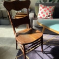 Dans une pièce ensoleillée, une Chaise de Bureau Américaine 1930 côtoie un canapé moderne et une table basse triangulaire sur un tapis violet. Brocante 93