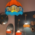 Chambre rétro avec suspension Dome Velours, lampes à franges colorées, miroirs et décoration murale en forme d'étoile. Brocante 93