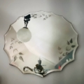 Le Miroir Gravé, orné de motifs floraux complexes, reflète avec élégance un lustre et une partie du plafond. Brocante 93